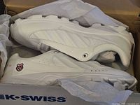 Side view of both sneakers inside box showing overall design and condition