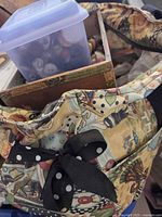 Canvas tote containing plastic case and cardboard box of buttons