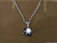 Necklace with flower pendant displayed on background