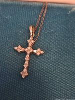 Close-up of gold cross pendant on silver chain