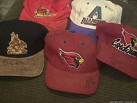 Group shot of five signed Arizona team caps