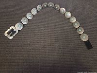 Full belt laid out showing buckle and 12 conchos