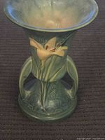 Front view showing lily motif, handles, flared rim