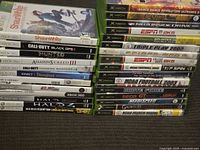 Two stacks of Xbox and Xbox 360 game cases showing spines