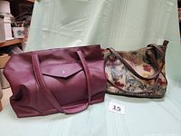 Burgundy leather handbag and Alfred Dunner floral purse side by side