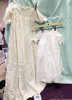 White christening gown and ecru baptism gown hanging