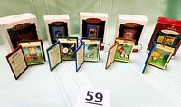 All five book ornaments standing open with boxes behind