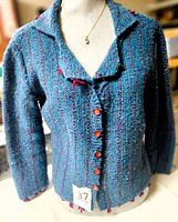 Front view of teal sweater on mannequin showing buttons and stripes