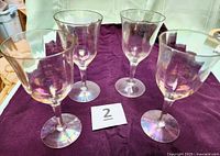 Four iridescent stemmed wine glasses on cloth