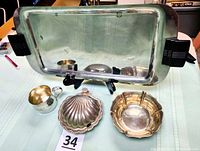 Group shot showing chrome tray, sterling bowl, shell dish, baby cup