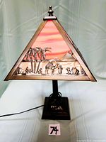 Full view of lamp showing stained glass pyramid shade and metal desert camel relief
