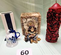 Group shot showing Royal Delft bell, Boyds figurine, red pillar candle and packaging