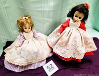 Both dolls side by side on fabric with lot number card