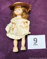 Front view of doll wearing dress, hat, shoes