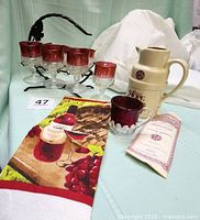 Kings Crown glasses in holder, pitcher, souvenir cup, certificate and towel overview