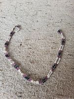 Full view of magnetic beaded necklace layout on carpet