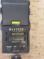 Rear control panel of camera flash showing ASA scale, auto-check button, on⁄off switch, Made in Japan mark