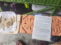 Overall lot with both terracotta slabs, one carved, manual and pad with pressed leaves