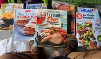 All seven softcover cookbooks laid out showing covers