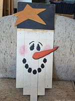 Snowman face plank sign with star, front view
