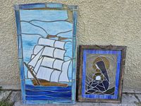 Both stained glass panels leaning against wall