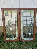Front view of both stained glass doors in brown wood frames