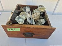drawer filled with assorted antique glass door knobs, backplates and locks