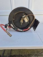 Front view of retractable hose reel showing hose and fittings