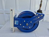 Side view of blue steel CoxReels hose reel showing mounting bracket and swivel