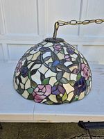 Side view of stained glass dome lamp showing floral and hummingbird design