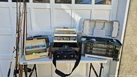 Overall lot with rods, three open tackle boxes, soft bag on table