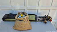 Overall lot showing bag of clubs and canvas pouch of balls