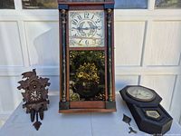Group shot of three clocks, key and pendulum