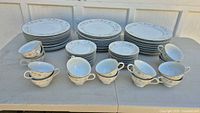 Entire set arranged showing three plate stacks, saucers, and handled cups