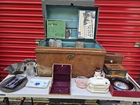 Open trunk displaying interior and contents with additional items arranged on table