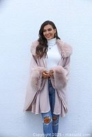 Woman wearing pink faux-fur trimmed coat