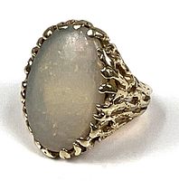 Front angle of gold ring displaying opal cabochon and textured bezel