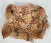 Front view of raku-fired dish showing overall form and glaze