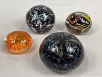 Group shot of four glass paperweights