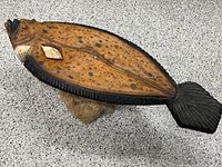 Top view of carved wood fish table on stone base