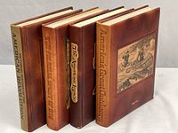 Four leather-bound volumes standing showing spines and front panel
