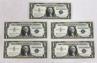 Five Series 1957B one-dollar silver certificates laid out, top note above four sequential notes