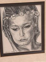 Close view of the sketch showing woman's face, floral headband, pencil detail