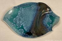 Full view of leaf-shaped porcelain platter showing overall crystalline glaze design
