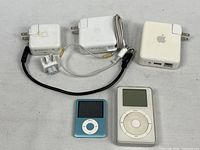 Lot overview showing iPods, three AC adapters, plug adapter and cables