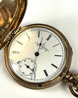 Open hunter-case showing white dial with Roman numerals and sub-seconds