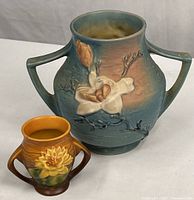 Front view of both Roseville Magnolia vases showing size difference and floral motifs