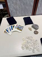 Loose tarot cards, two pouches, three stones visible