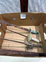 Box containing three swords and one fishing rod with reel