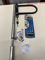 All four items laid out: Bluemel pump, Bell U-lock with keys, American Tourister padlock in package, Park Tool CCP-2 in package